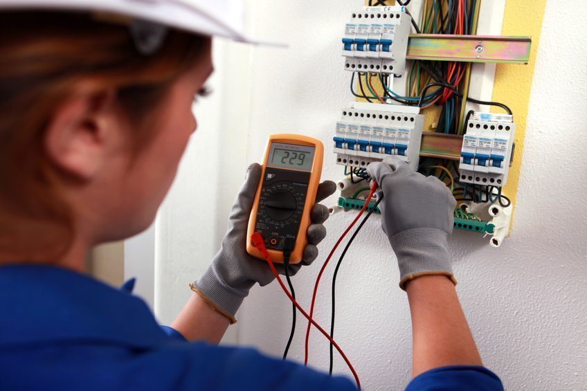 11775495 - female electrician checking a fusebox